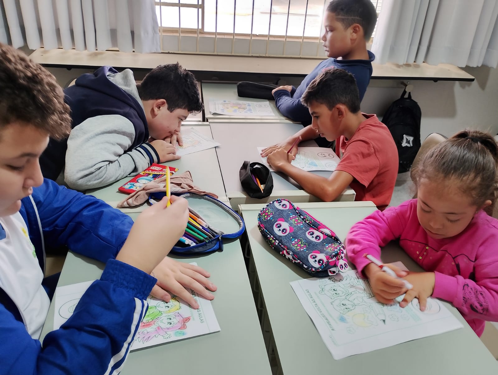 Alunos em atividade de pintura em sala