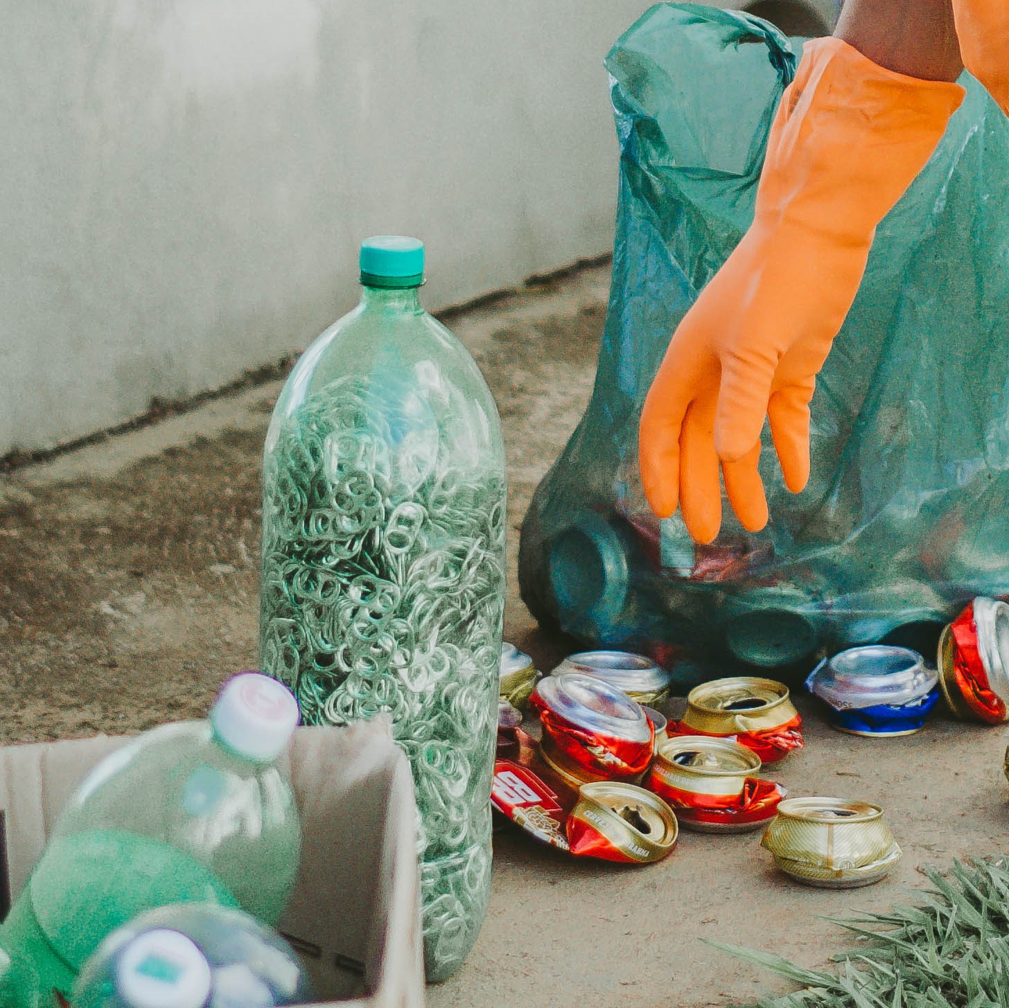 Materiais recicláveis separados — garrafas PET, latas e tampinhas