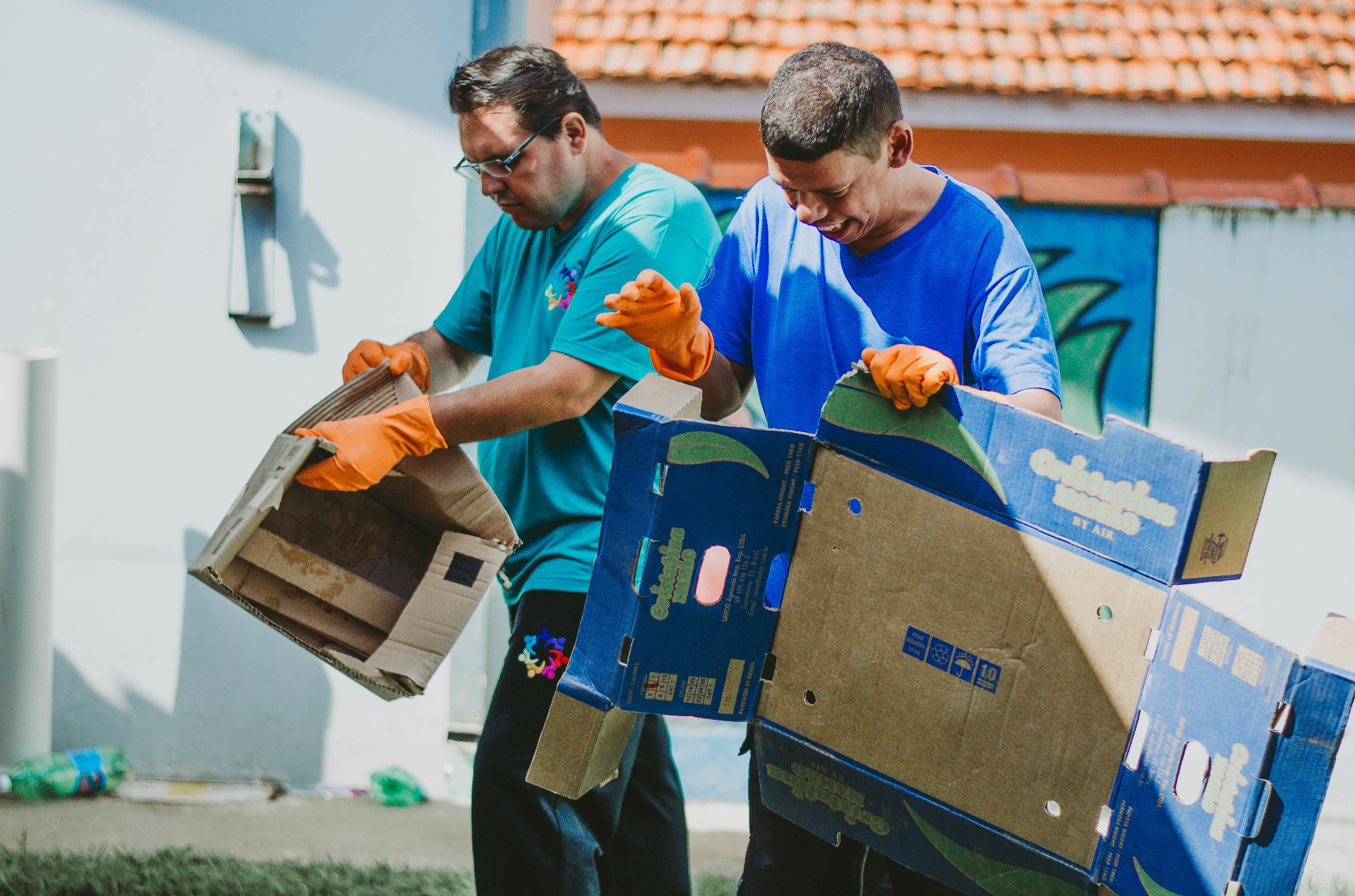 Usuários da APAE manuseando caixas de papelão em ação de reciclagem