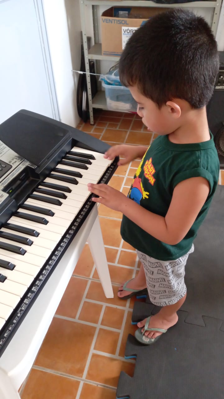 Criança em atividade musical com teclado